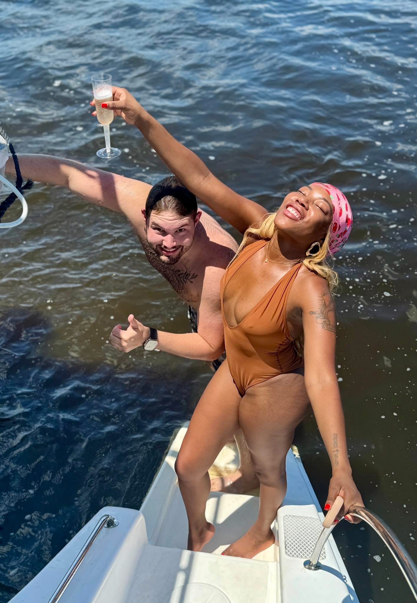 Couple celebrating with champagne on the deck of Now and Zen sailing catamaran