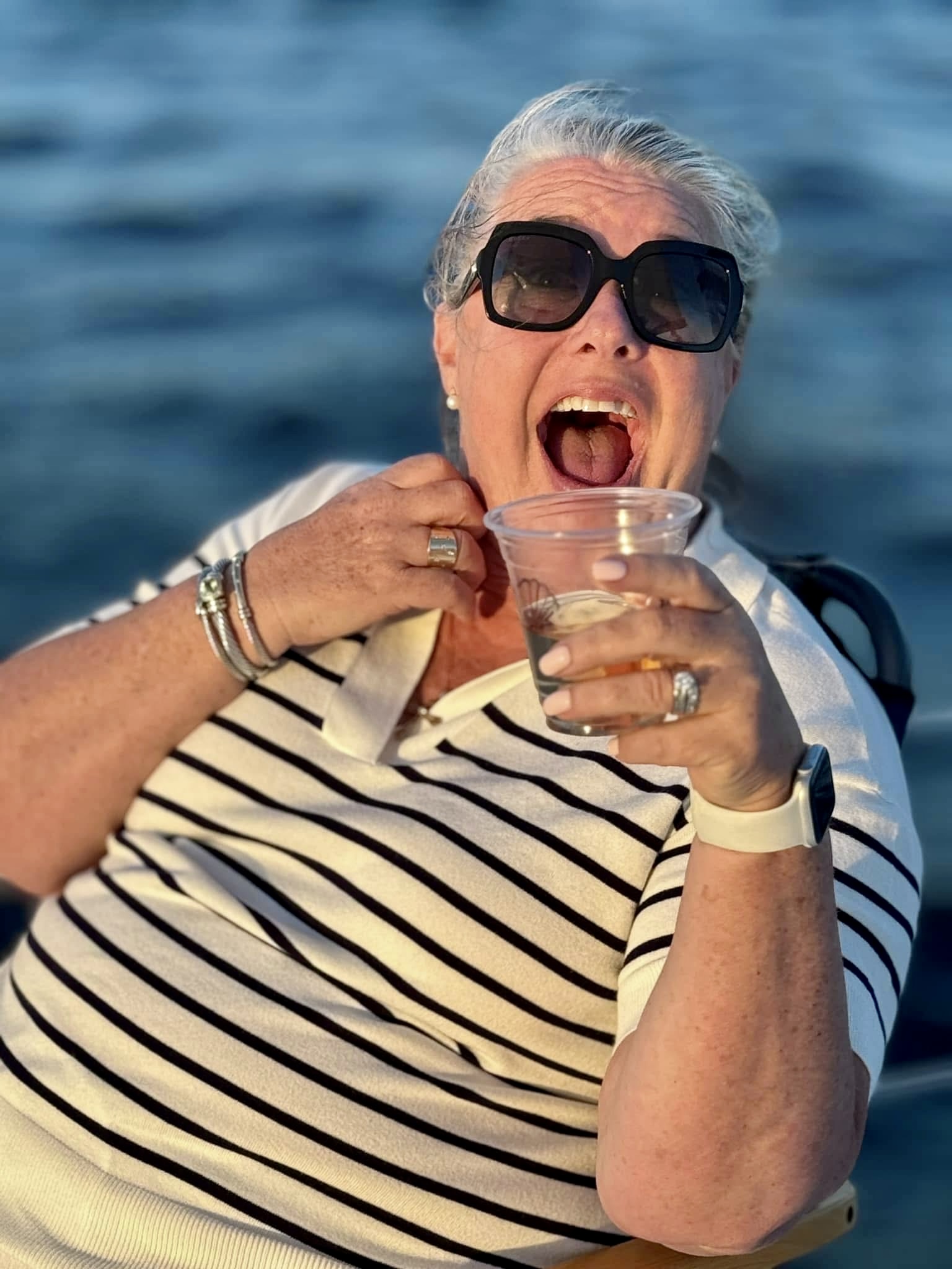 Guest having a great time with a drink on the deck of Now and Zen catamaran on the St Johns River